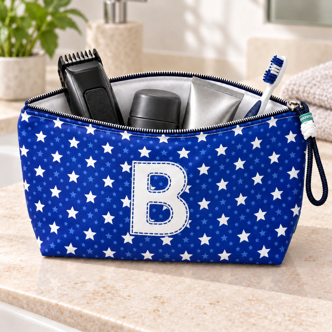 Bolsa Alex azul com letra B aberta, com produtos de higiene masculina, interior branco e fecho metálico.