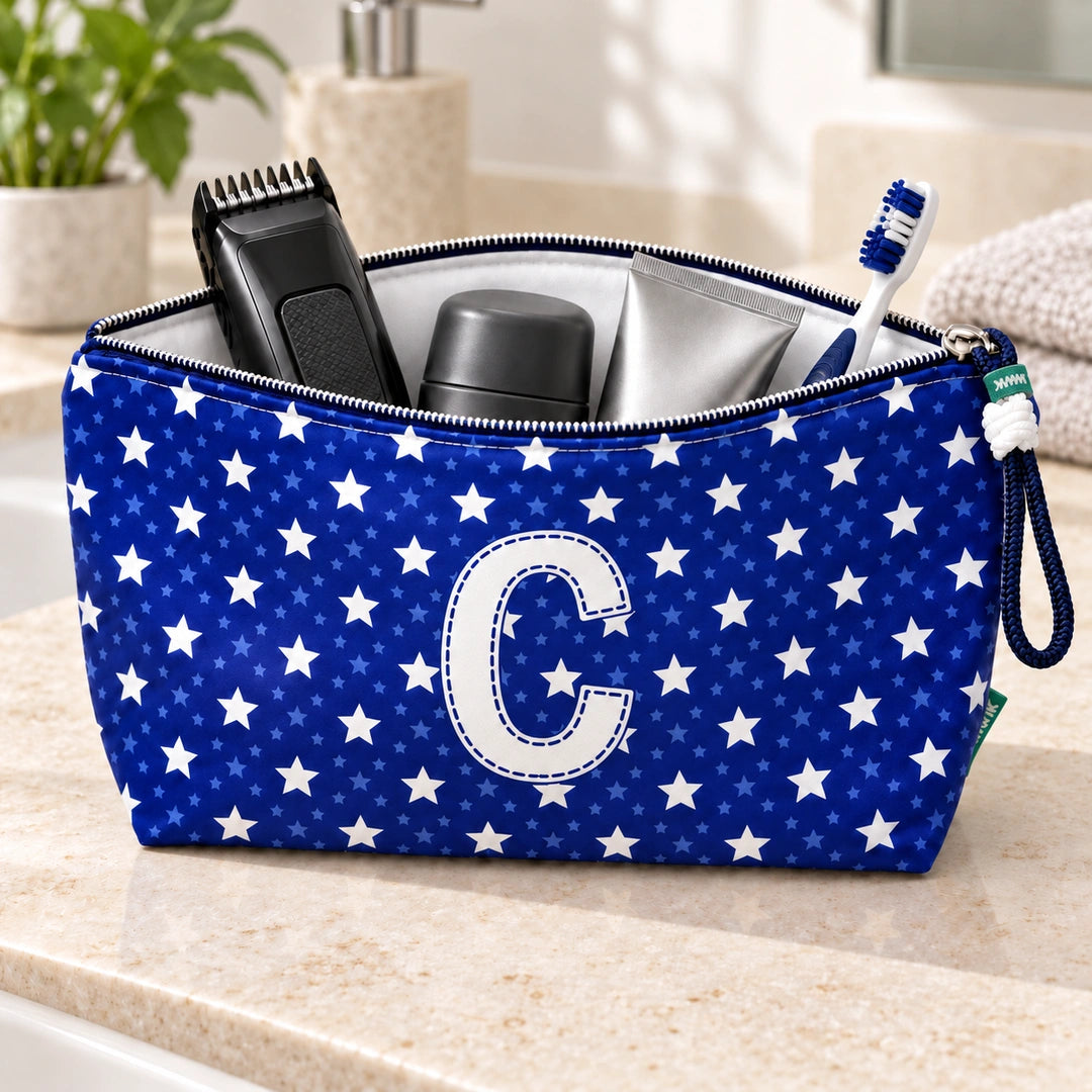 Bolsa Alex azul com letra C aberta, com produtos de higiene masculina, interior branco e fecho metálico.