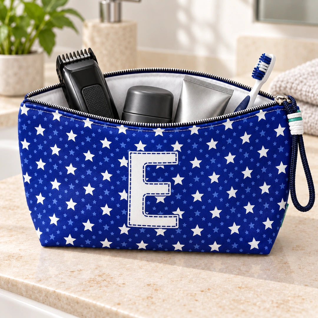 Bolsa Alex azul com letra E aberta, com produtos de higiene masculina, interior branco e fecho metálico.