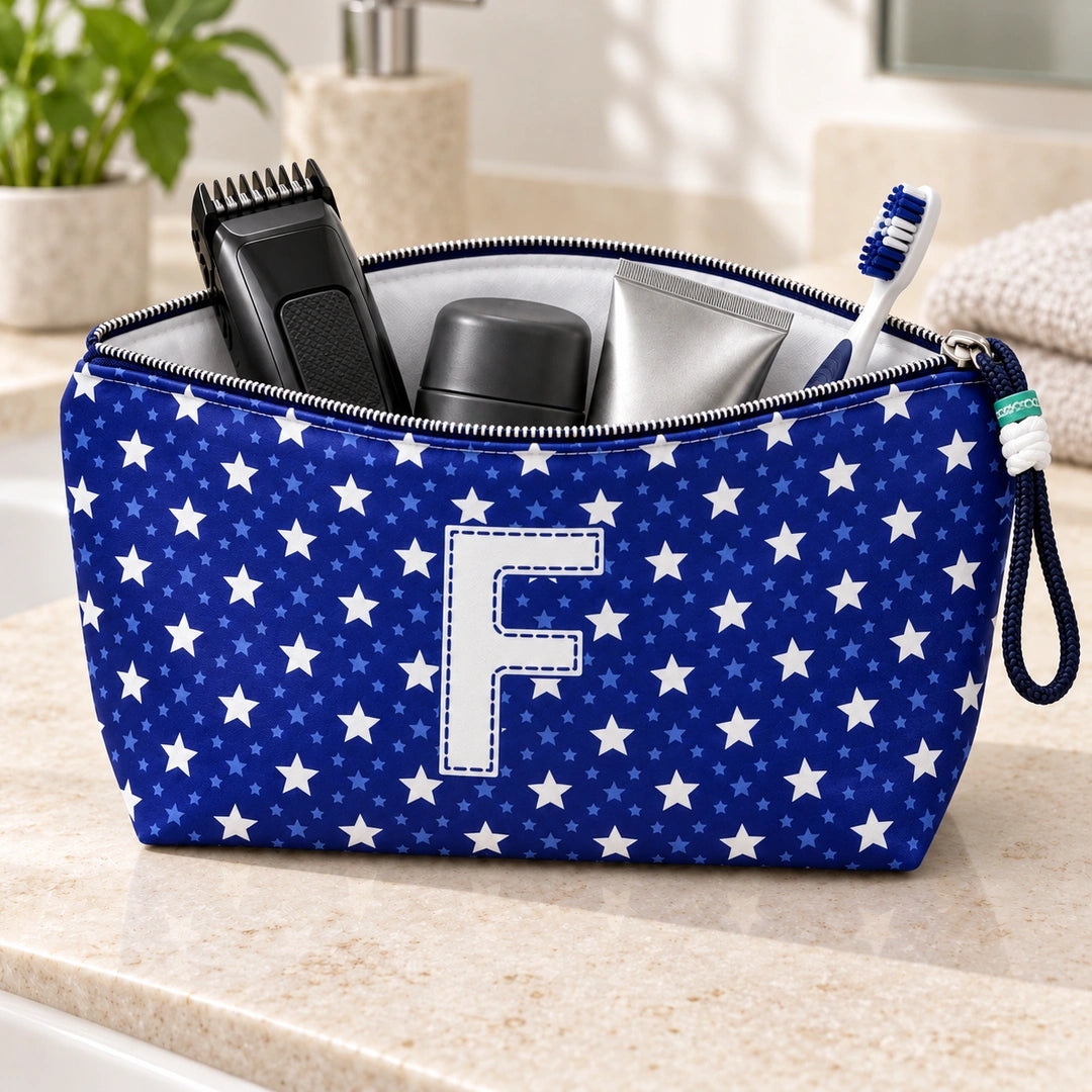 Bolsa Alex azul com letra F aberta, com produtos de higiene masculina, interior branco e fecho metálico.
