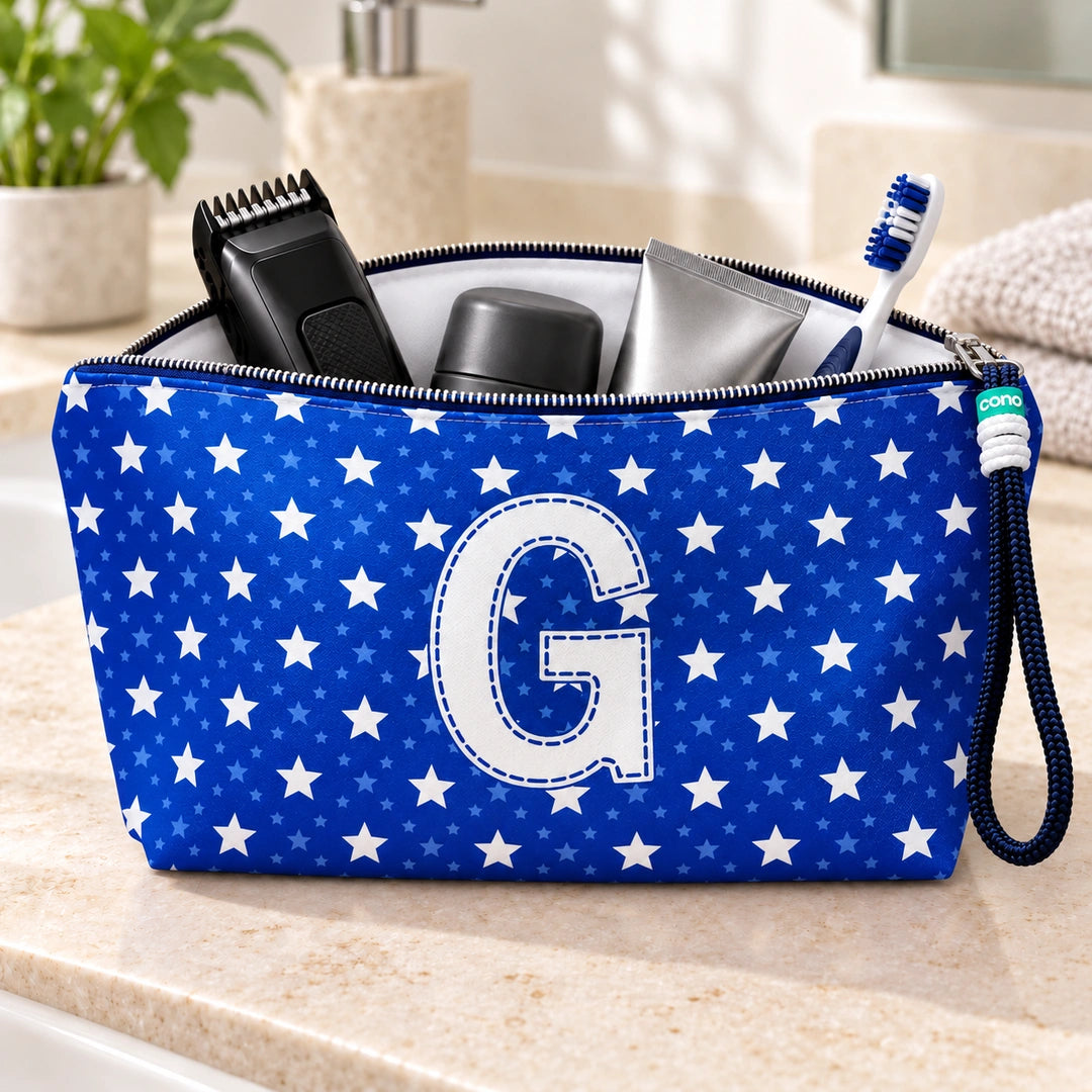 Bolsa Alex azul com letra G aberta, com produtos de higiene masculina, interior branco e fecho metálico.