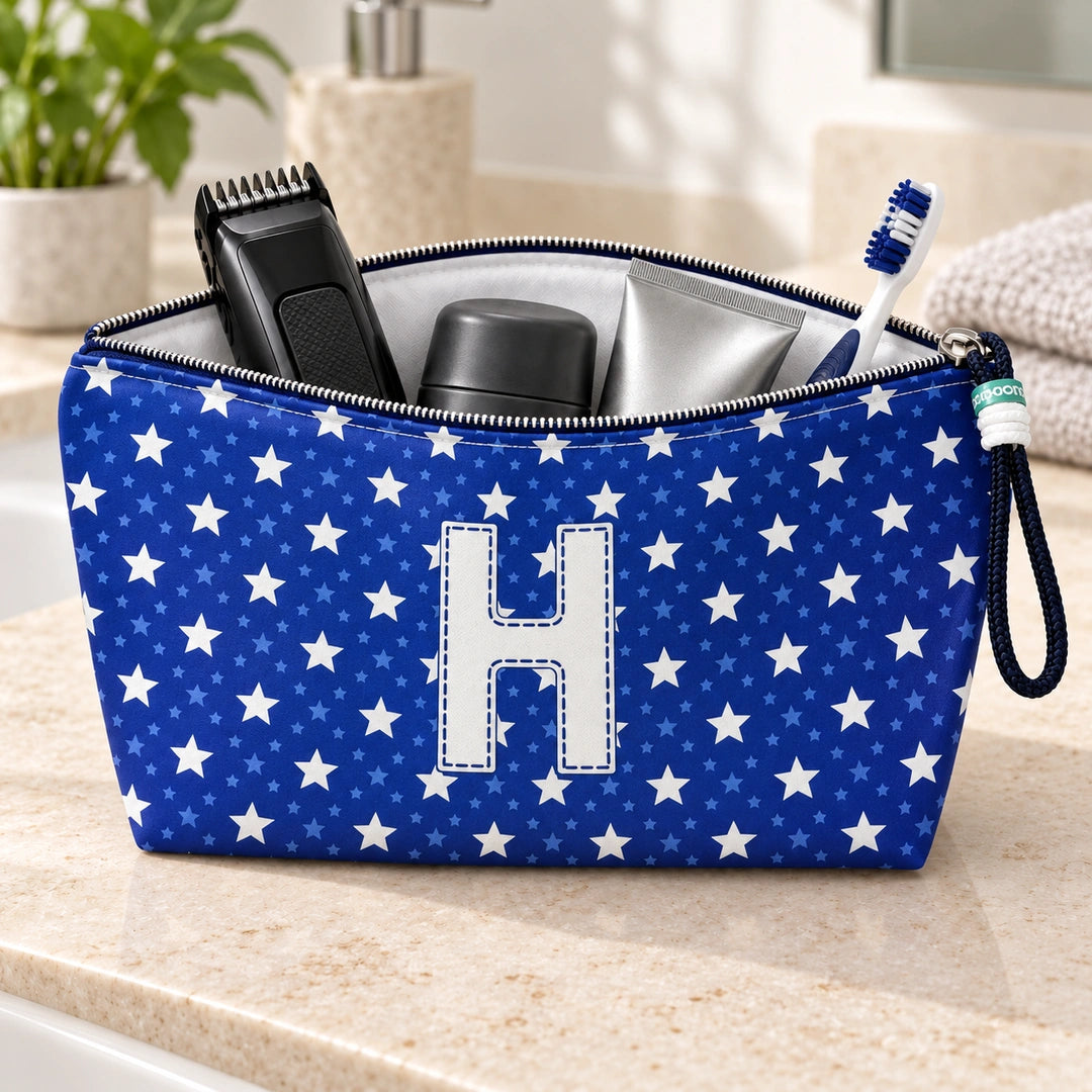 Bolsa Alex azul com letra H aberta, com produtos de higiene masculina, interior branco e fecho metálico.