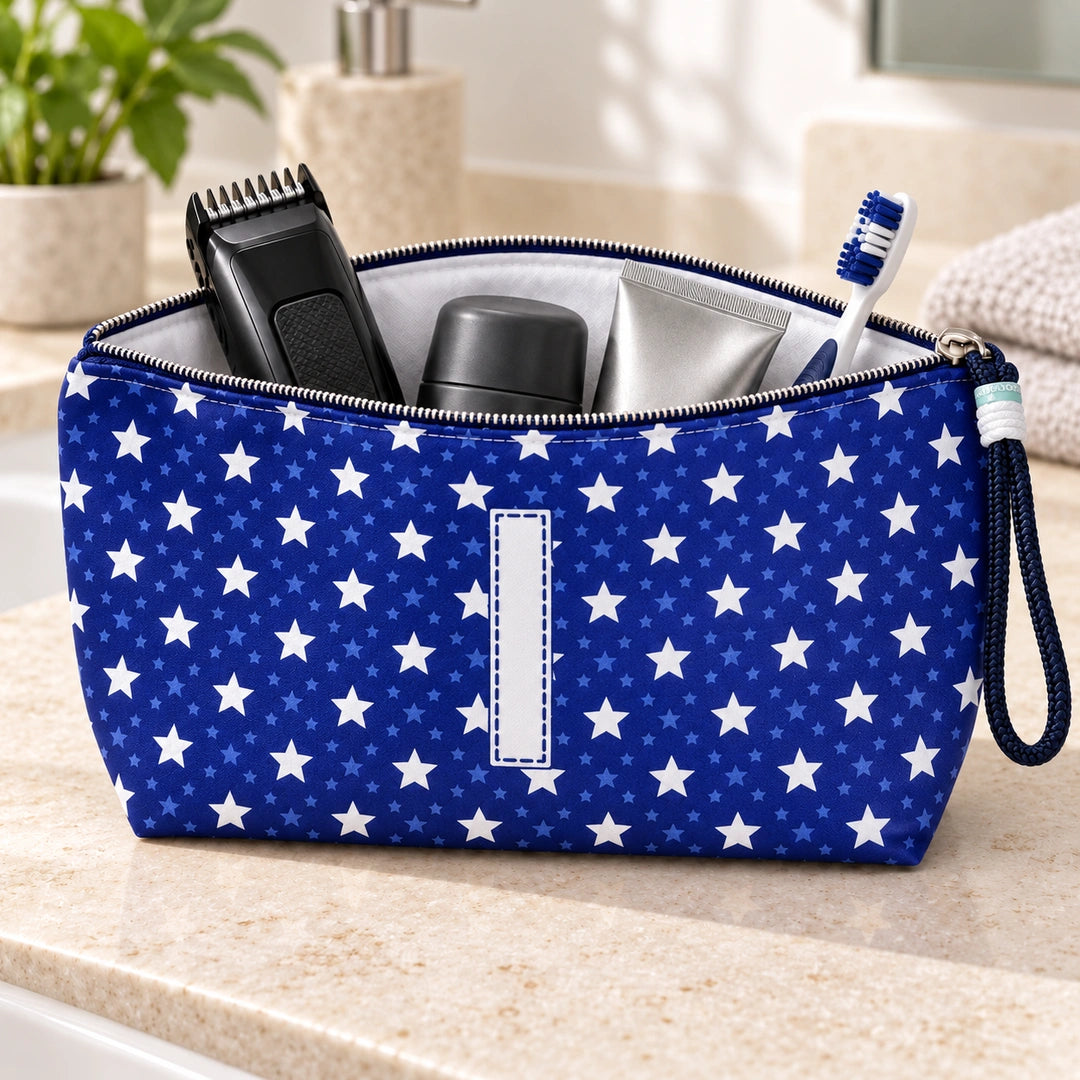 Bolsa Alex azul com letra I aberta, com produtos de higiene masculina, interior branco e fecho metálico.