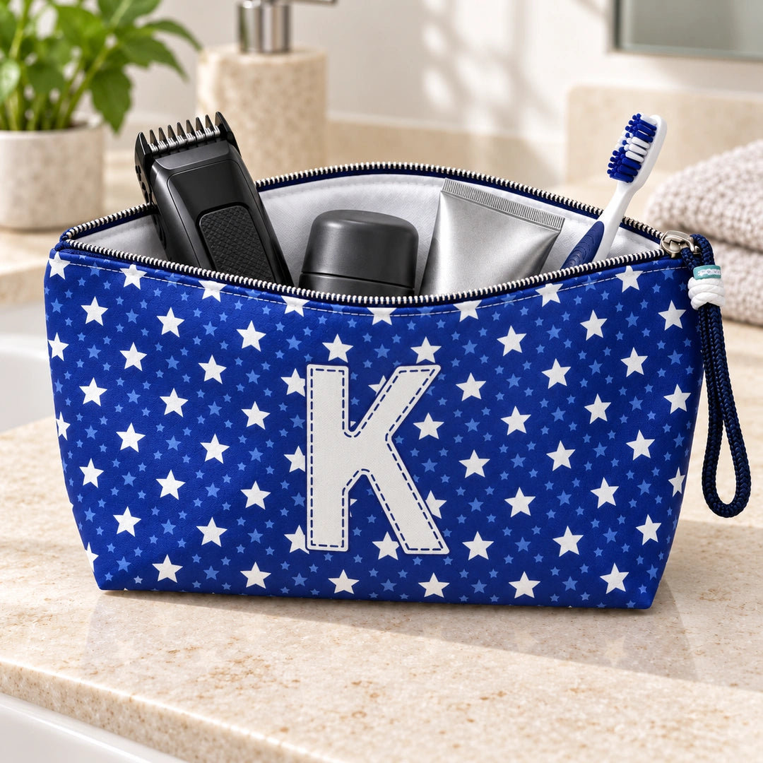 Bolsa Alex azul com letra K aberta, com produtos de higiene masculina, interior branco e fecho metálico.