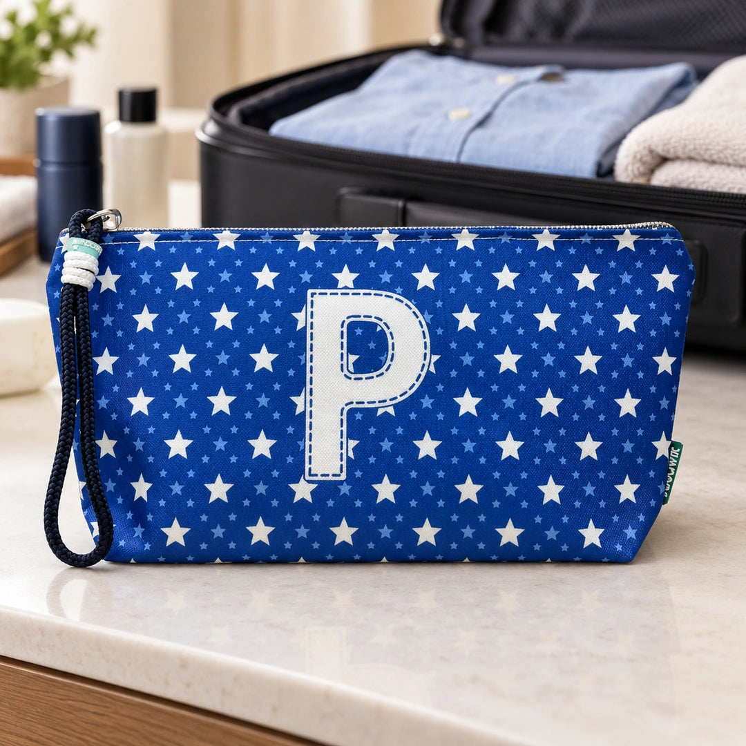 Bolsa Alex azul com letra P fechada num cenário de viagem com mala, roupa e artigos de higiene masculina.