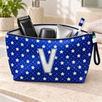 Bolsa Alex azul com letra V aberta, com produtos de higiene masculina, interior branco e fecho metálico.