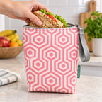 Bolsa isotérmica para snacks Hexágonos Interligados Rosa em utilização – com snacks no interior