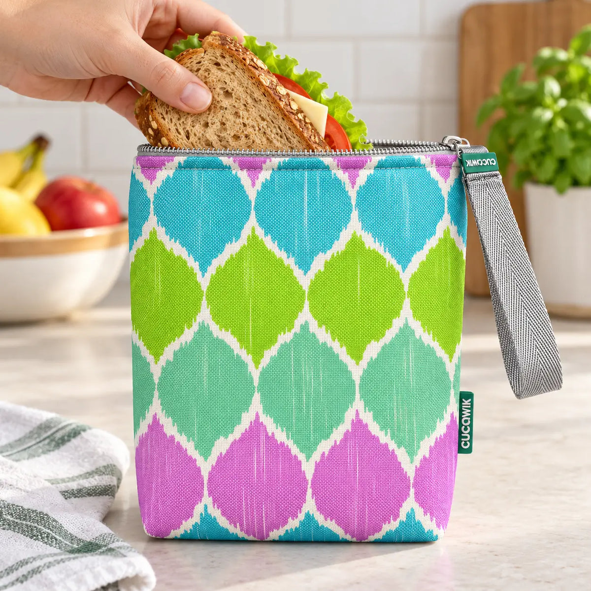 Bolsa isotérmica para snacks Ikat Pastel Rosa Verde Azul em utilização – com snacks no interior