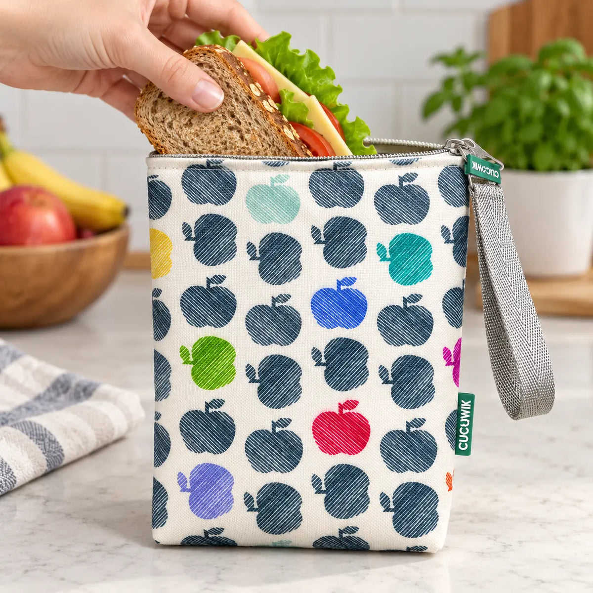 Bolsa isotérmica para snacks Maçãs Coloridas em utilização – com snacks no interior