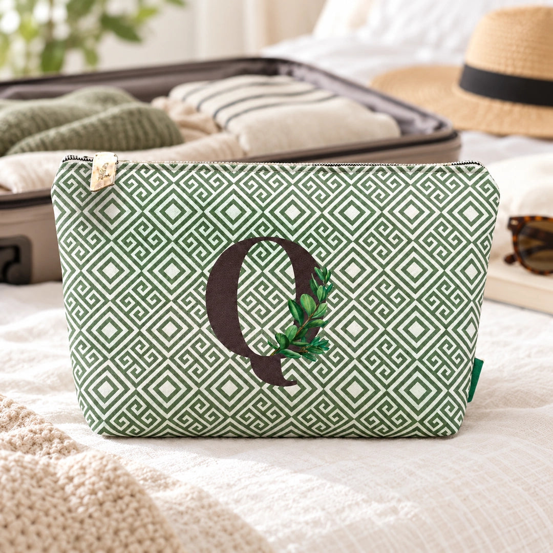 Bolsa Guta verde letra Q num ambiente de viagem.