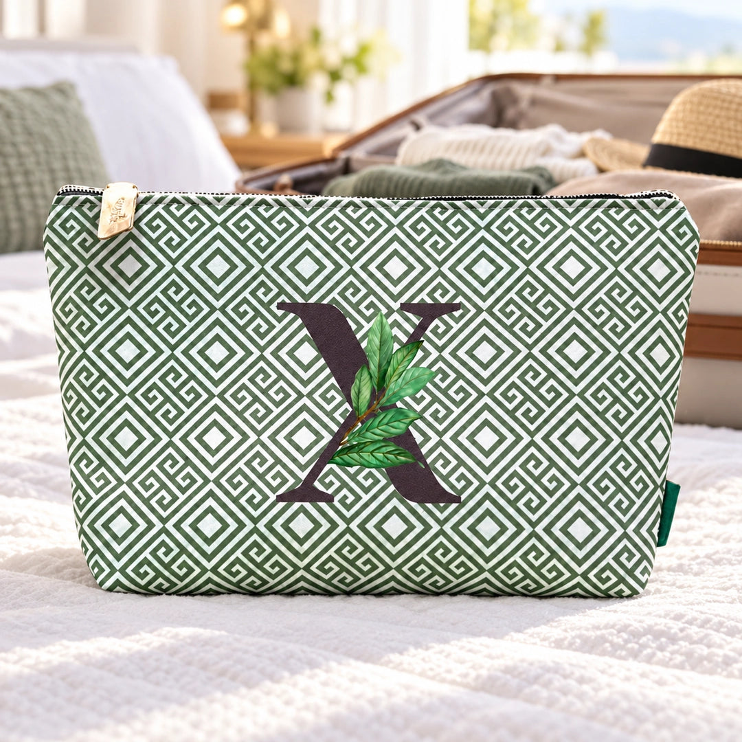Bolsa Guta verde letra X num ambiente de viagem.