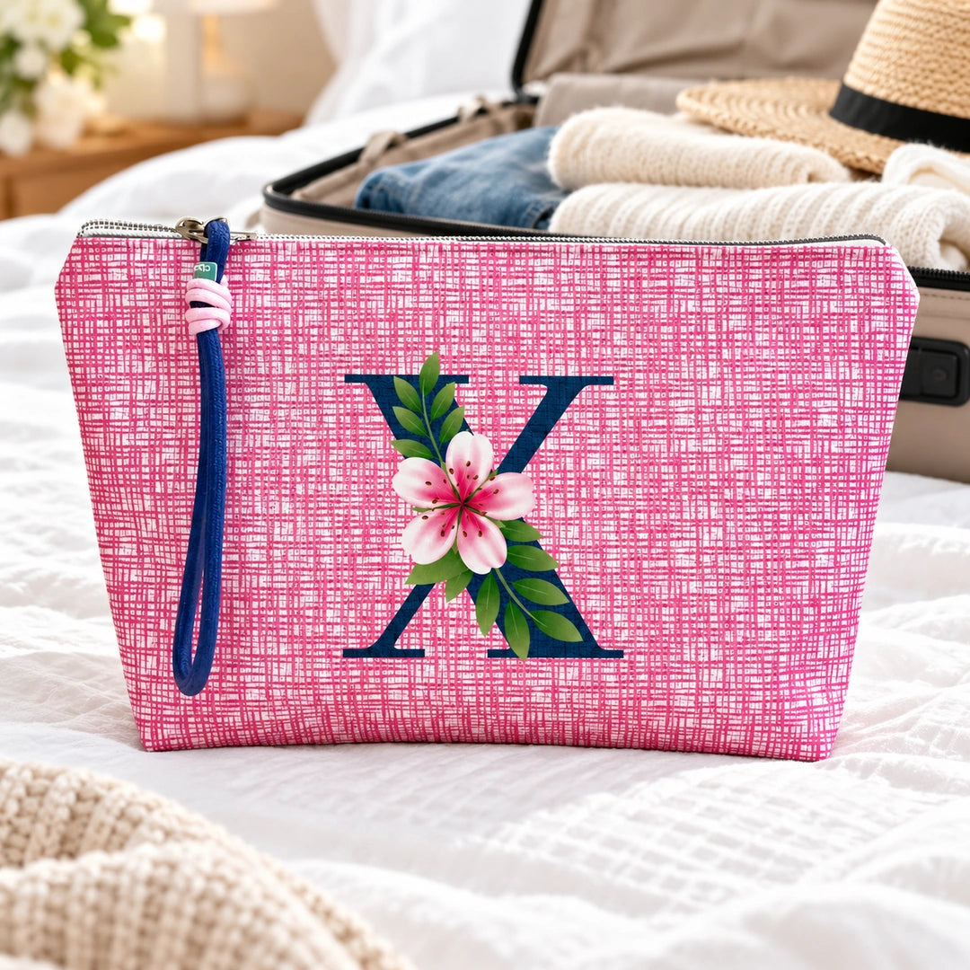 Bolsa Vera rosa letra X — ambiente de viagem.