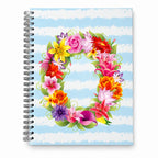 Caderno de argolas A5 com a letra O na capa, padrão floral com flores coloridas em tons suaves sobre fundo azul | Cucawik