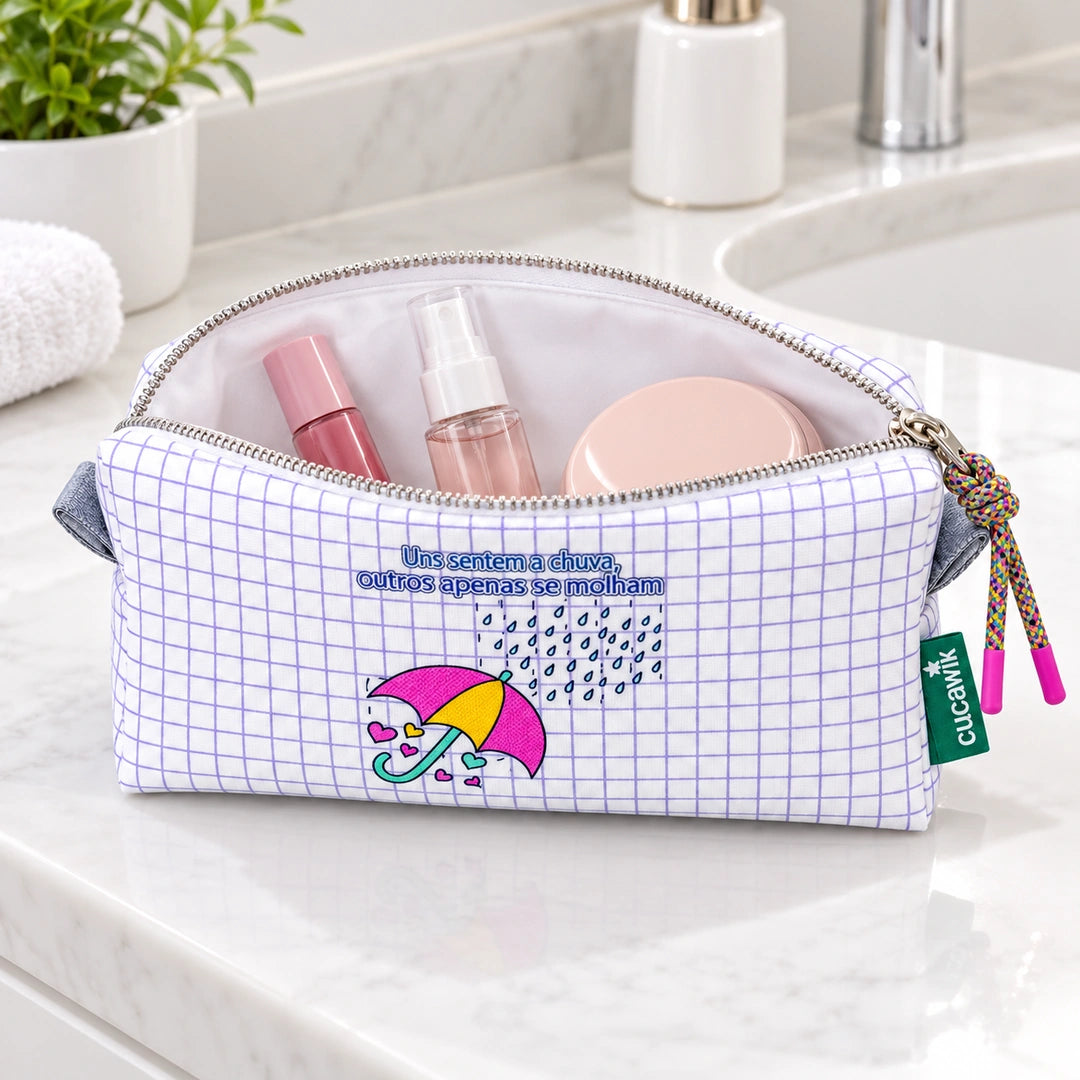 Necessaire Médio Impermeável Eden "Uns Sentem a Chuva, Outros Apenas se Molham" — aberta com cosméticos