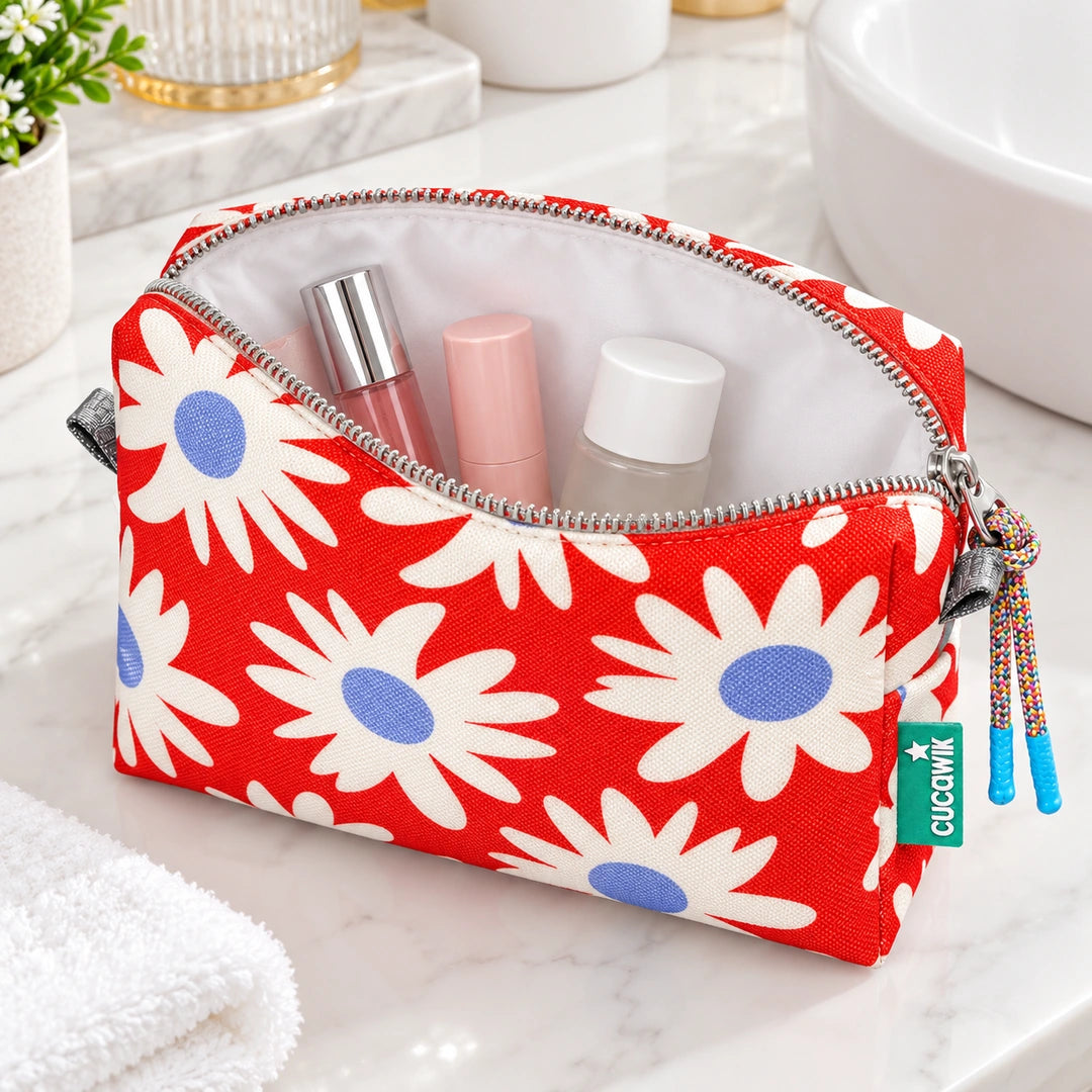 Necessaire Grande Impermeável Eden Margaridas Fundo Laranja — aberta com cosméticos