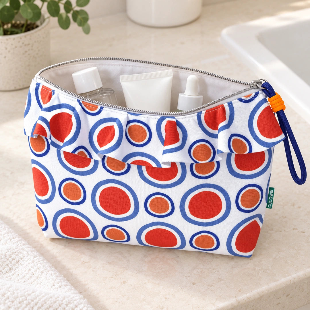 Necessaire Grande Impermeável Maggy com Folho Círculos Pop Laranja Azul — aberta com produtos de higiene