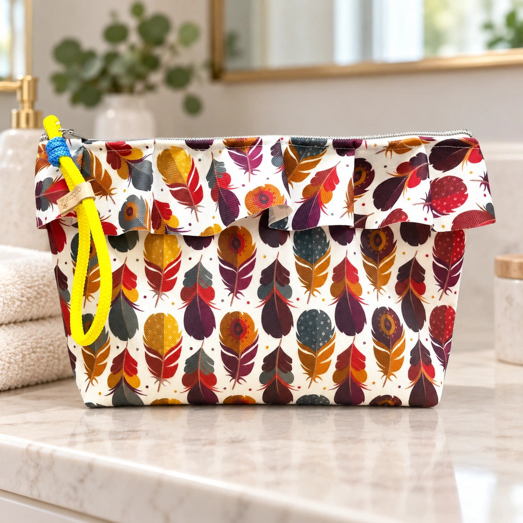 Necessaire Grande Impermeável Maggy com Folho Penas Coloridas — fechada em ambiente de casa de banho
